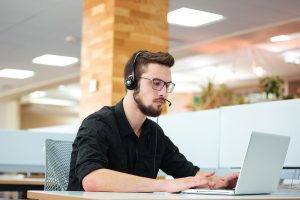 Businessman working on laptop computer in call center